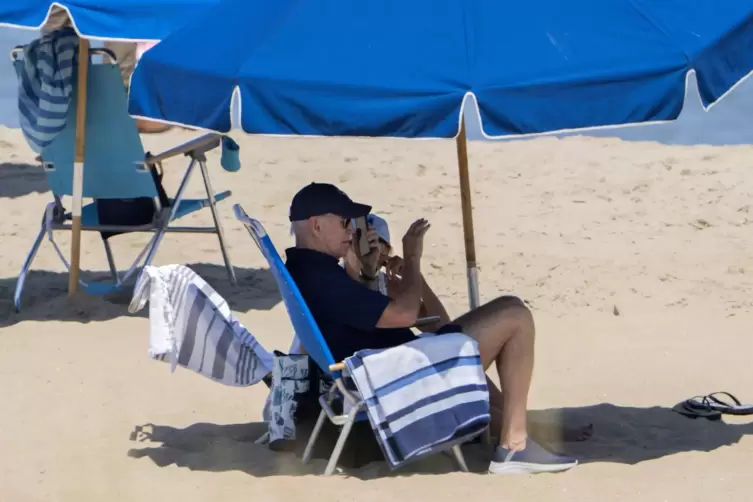 Joe und Jill Biden sitzen unter einem Sonnenschirm am Strand von Rehoboth Beach.