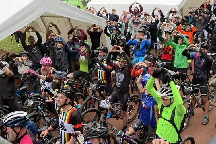 Vor dem Start zeigen die Mountainbiker Herz und schw&ouml;ren gemeinsam, sich auf dem Trail zu benehmen.