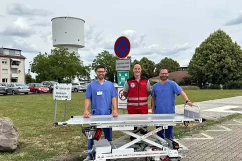 Die neue Hubschraubertrage vor dem Hubschrauberlandeplatz der Asklepios Südpfalzklinik Kandel. Von links nach rechts: Daniel Sch