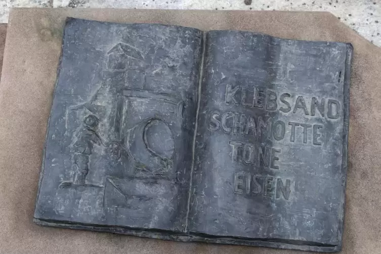 Ein Schild am Janusbrunnen mit der Aufschrift „Klebsand-Schamotte-Ton-Eisen“.