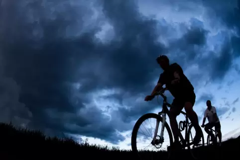 Zwei Radfahrer geraten in ein Unwetter. 