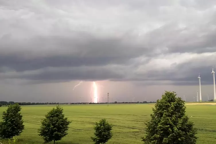 Ein Blitz schlägt in der Nähe einer großen Grünfläche ein. 