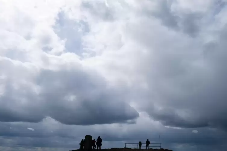 Über den Wanderern ziehen Gewitterwolken auf. 