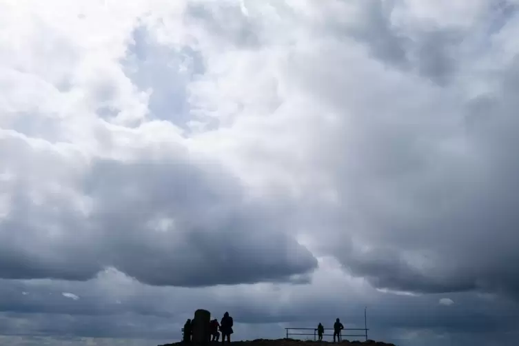 &Uuml;ber den Wanderern ziehen Gewitterwolken auf. 