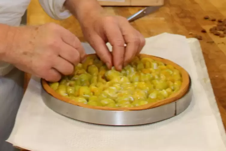 Meisterh&auml;nde beim Zubereiten der saisonalen Spezialit&auml;t; Tarte aux mirabelles, Mirabellentarte.
