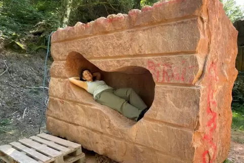 Lädt ein zum Päuschen und zur Begegnung mit dem Westpfälzer Sandstein: Birgit Cauer in ihrer Skulptur „Lapi-Log/Lapi-Liege“. 