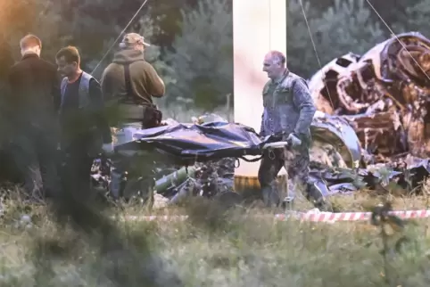 Menschen tragen einen Leichensack aus dem Wrack eines abgestürzten Privatjets in der Nähe des Dorfes Kuschenkino in der Region T