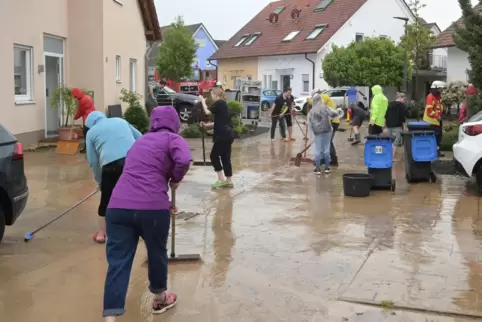 Nach dem Starkregen Anfang Mai: Mechtersheimer versuchen ihre Straße vom Schlamm zu befreien. 