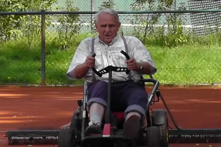 Platzwart Horst Ebenrecht zieht mit dem Rasenm&auml;her-Gokart den Platz ab.