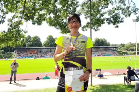 Astrid Eisenbarth von der TSG Eisenberg mit ihrer Goldmedaille und der Urkunde für den DM-Sieg über die 400 Meter in der Klasse 