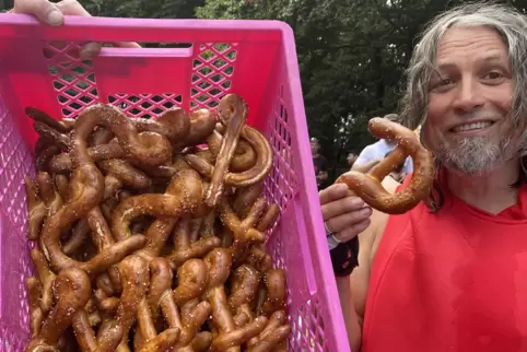 Ein Klappradfahrer lässt sich im Ziel ein Laugenscharnier schmecken.