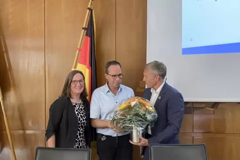 Einen Blumenstrauß für Peter Schmidt: Landrat Ralf Leßmeister (rechts) und Erste Kreisbeigeordnete Gudrun Heß-Schmidt gratuliere