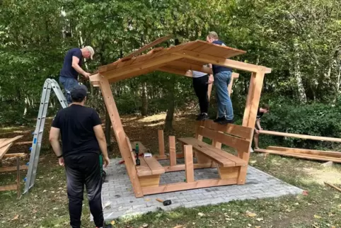Helfer des Jugendforums bauen die Sitzlaube auf. 