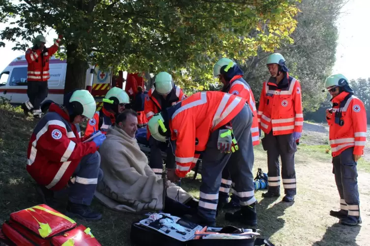 Rettungsdienstler versorgen den Geretteten an Land. 