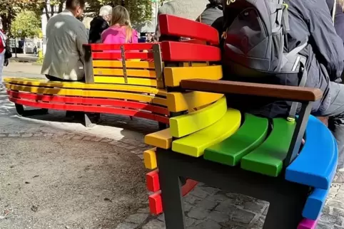 Die Bank hat eine S-Form und ist in den Regenbogenfarben gestrichen. Eine Beschilderung gibt es nicht, sie soll für sich allein 