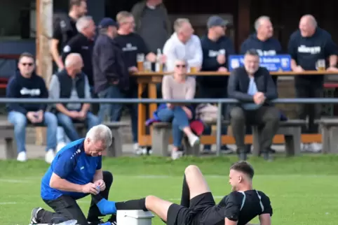 TuS-Physiotherapeut Peter Baier behandelt Schiedsrichter Matthias Munkler. 