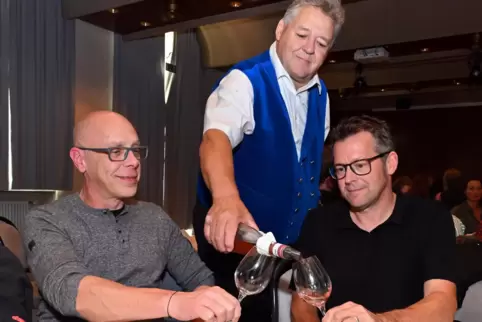 Günther Sommer von der Trachtengruppe versorgt Steffen Kleiss (links) und Mischa Hammann mit einem Tropfen vom Weingut Fleischma