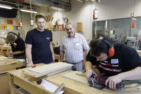  Christian Fischer und Kurt König schauen Philipp Hubig von der Handwerkskammer der Pfalz bei seiner Prüfung über die Schulter.