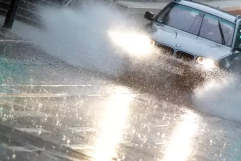Hoffentlich nicht zu schnell unterwegs: Auto auf regennasser Straße (Symbolbild).