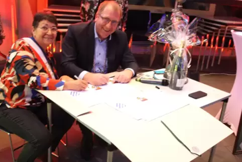 Beatrix Lacroix Mfouara und Torsten Bechtel unterzeichnen die neue Partnerschaftsurkunde.
