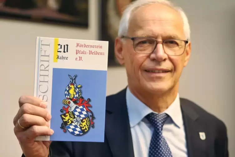 Vereinsvorsitzender Stefan Spitzer präsentiert die Festschrift, die der Förderverein anlässlich des Jubiläums herausgebracht hat