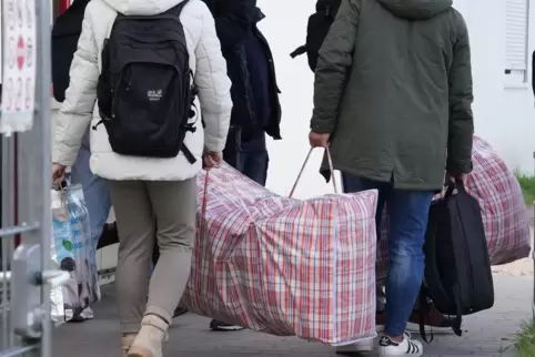 Flüchtlinge aus Syrien kommen mit ihrem Gepäck in einer Unterkunft in Hamburg an.