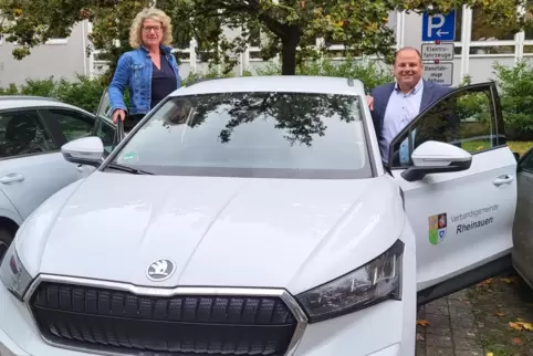 Am E-Auto, das Bürger von der Verbandsgemeinde Rheinauen ausleihen können: Bürgermeister Patrick Fassott und seine Assistentin A