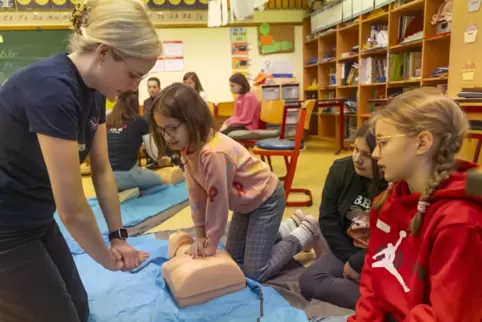 Medizinstudentin Paula (links) zeigt Liana an einer Puppe, wie man eine Herzdruckmassage durchführt. Chiarra und Smilla schauen 
