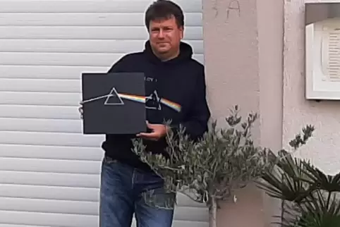 Michael Weickenmeier mit Pink-Floyd-Pullover und -Platte vor dem Eingang des Provinzkinos in Enkenbach. 