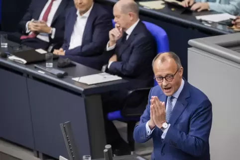 Nur kurzzeitig auf einer Wellenlänge: Bundeskanzler Olaf Scholz (SDP) und Unionsfraktionschef Friedrich Merz (am Pult).