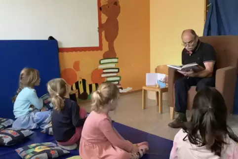 Ein Großvater liest im Rahmen der Vorlesewoche in der Kita Weierhof den Froschkönig vor. 