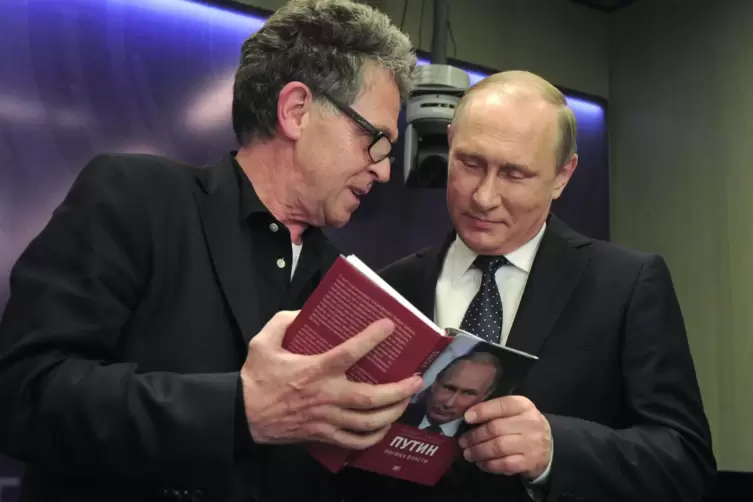 Der deutsche Journalist Hubert Seipel (links) schaut sich 2016 mit Wladimir Putin sein Buch an.