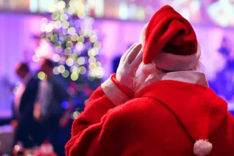Ein als Weihnachtsmann verkleideter Mensch geht 2016 in Berlin im Hotel Estrel bei der traditionellen Weihnachtsfeier für Obdach