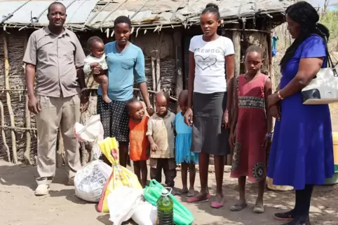 Mitarbeiter aus dem Projekt AJAM von Pater Shirima übergeben einer Famile Nahrungsmittel, die über die Aktion „Mais fer Afrika“ 