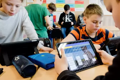 Grundschüler arbeiten im Unterricht am Tablet. 