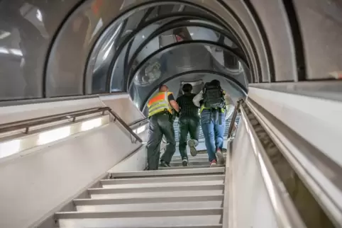 Polizisten begleiten einen abgelehnten Asylbewerber in ein Flugzeug.