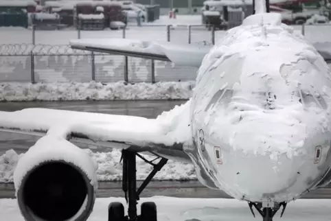 Verschneites Flugzeug am Münchner Flughafen. 