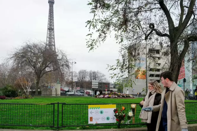 Fußgänger gehen in der Nähe des Eiffelturms an Blumen an dem Ort vorbei, an dem ein mutmaßlicher Islamist einen deutschen Touris