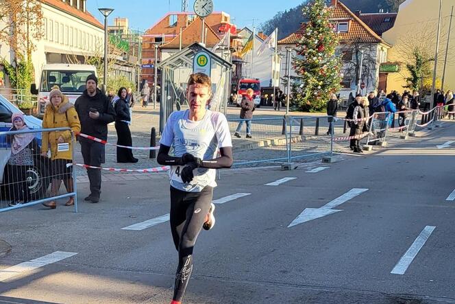 Herren-Sieger Tim Könnel stoppt in Landstuhl beim Zieleinlauf seine Zeit. Er gewann in 22:19,47 Minuten.