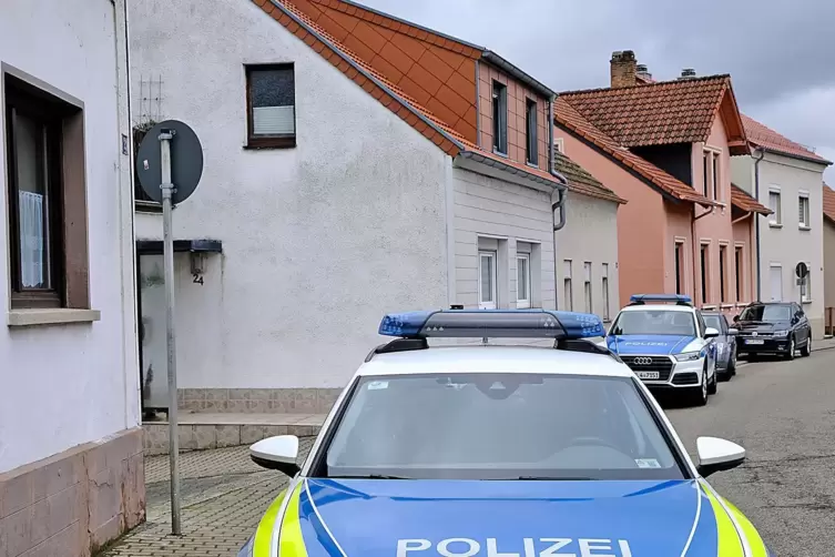 Polizeiautos halten in der Friedrich-Ebert-Stra&szlig;e vor Nachbarh&auml;usern des Leichenfundorts, des Hauses rechts im Bild.