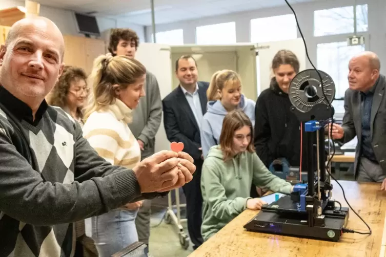 Während Joachim Seltmann das erste Produkt des 3D-Druckers präsentiert, folgen die anderen dem Geschehen. 