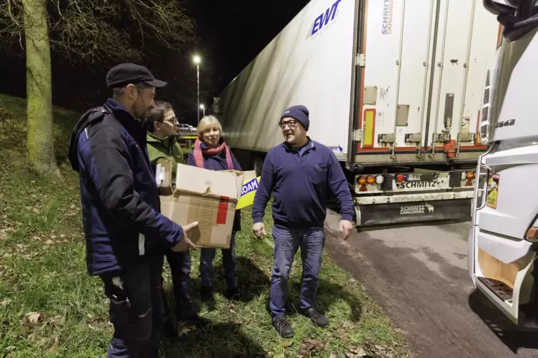 Die Helfer des Nikolaus’: Benjamin Layes, Dominik Schek und Regina Wilhelm unterhalten sich mit dem Lastwagenfahrer Frank Jungma