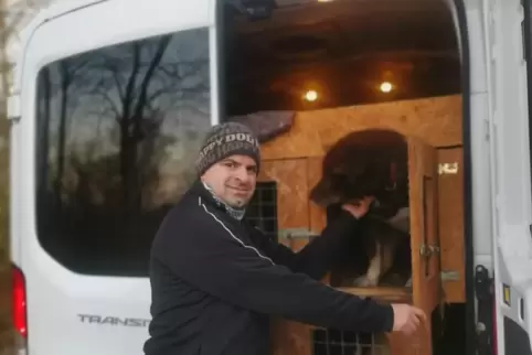 Dominik Brendel öffnet die Tür einer Hundebox. 