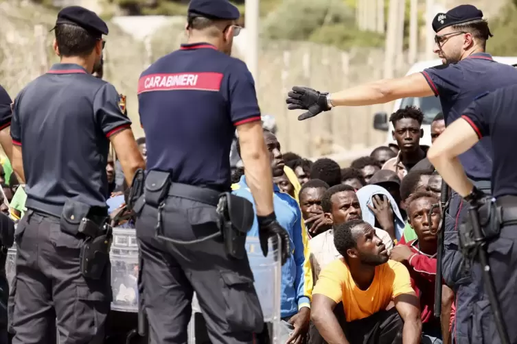 Europa setzt stärker auf Abschottung: Italienische Carabinieri sprechen mit Migranten in einem Aufnahmezentrum auf der Insel Lam
