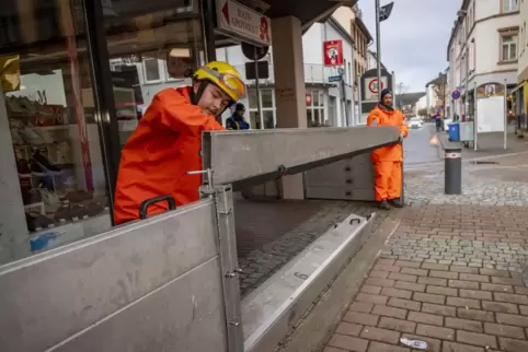 Am Ärztehaus in der Poststraße bauen Jan-Lukas Kaufmann und Martin Steck (v.l.) eine mobile Hochwasserschutzwand auf.