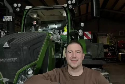 Landwirt Boris Ronstadt vor dem Traktor des Betriebs Binder aus Gerolsheim.