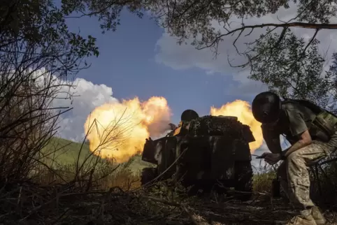 Ein ukrainischer Soldat steht hinter einer Panzerartillerie, die an einer Frontlinie in der Region Charkiw auf russische Truppen