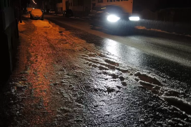 Ein dicker Blitzeis-Panzer aus gefrorenem Regen &uuml;berzieht am Morgen die Altheimer Stra&szlig;e und Autoscheiben in Mittelbach. 
