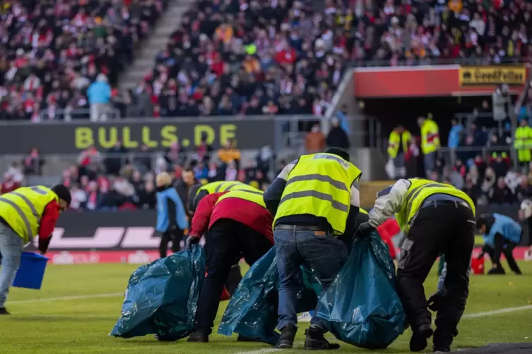 Ordner sammeln Schokotaler auf, die Fans beim Bundesliga-Spiel 1. FC Köln - Borussia Dortmund aus Protest gegen die Investorenpl