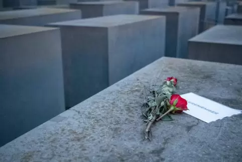  Rosen mit dem Schriftzug "#weremeber" (wir erinnern uns) liegen auf einer Stele im Berliner Holocaust-Mahnmal.
